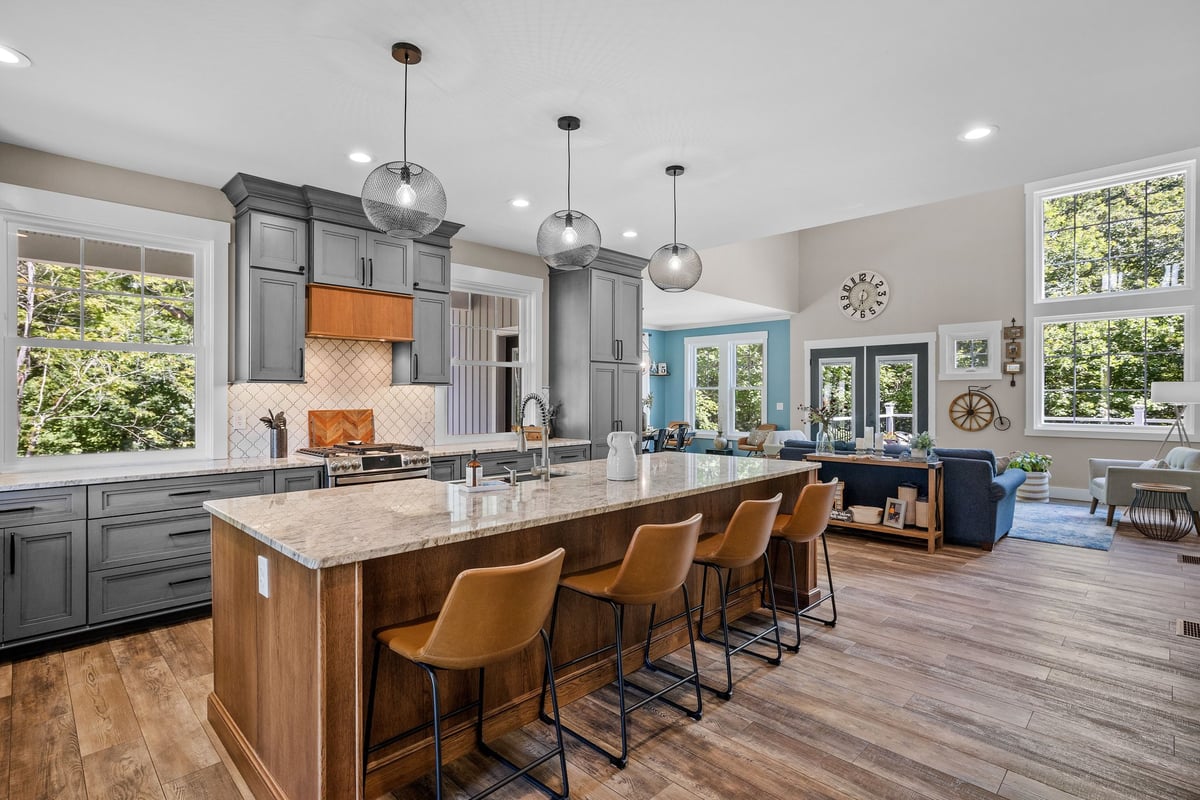 Family reviewing financial documents and college housing plans together at a kitchen table — parent buyer and college student reviewing a property analysis