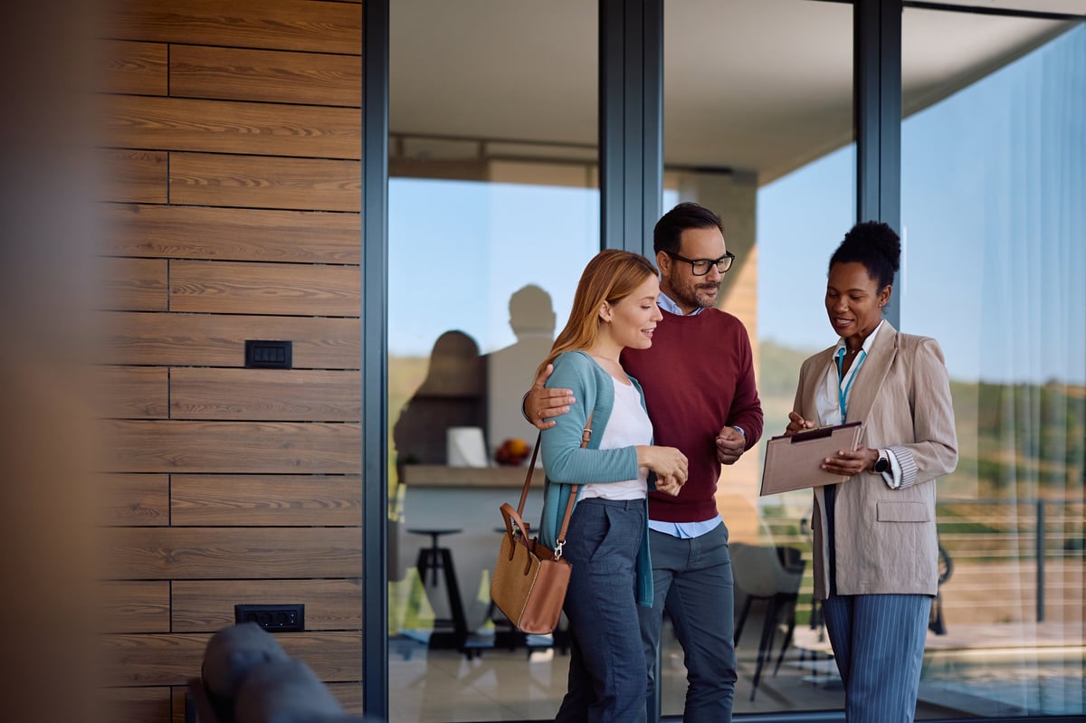Local real estate agent walking through a campus-area neighborhood with clients reviewing a property