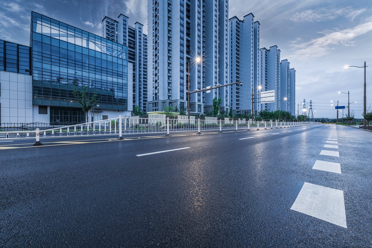 Modern urban street with high-rise apartments and tree-lined sidewalks