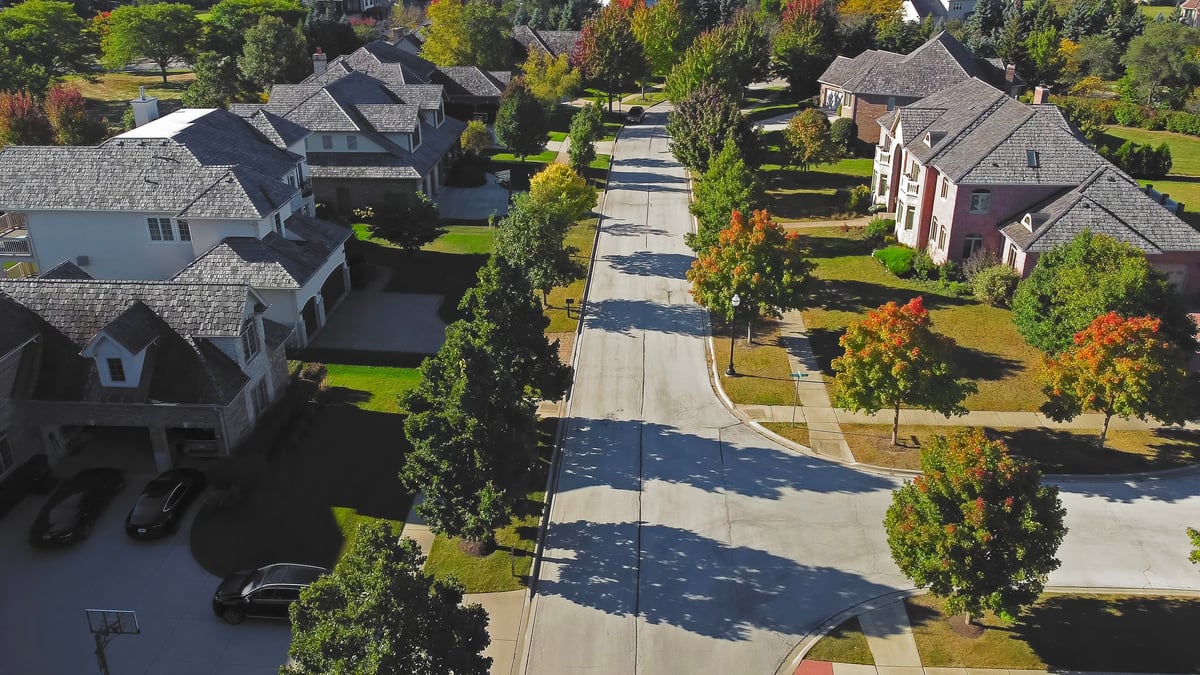 Peaceful residential street with tree-lined sidewalks and well-maintained homes
