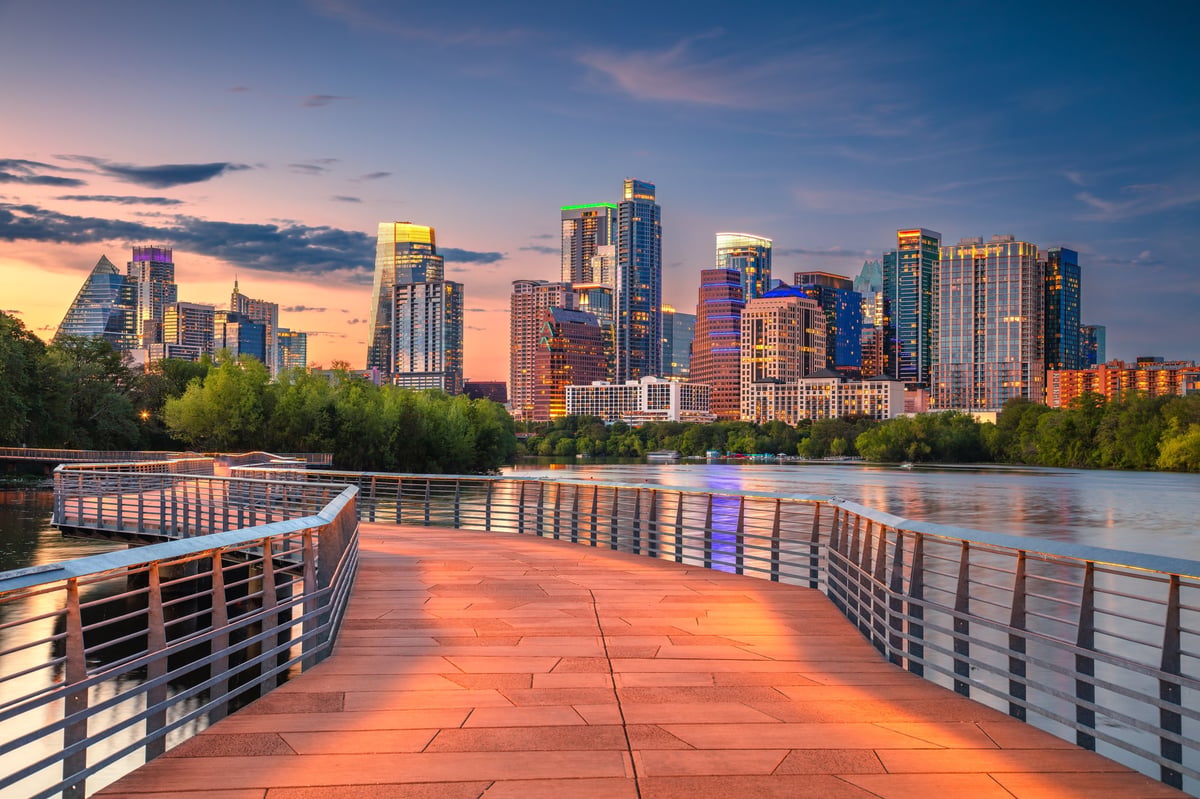 Austin Texas skyline at sunset with the Colorado River — campus-area residential context for UT Austin condo buyers reviewing HOA, insurance, and financing considerations