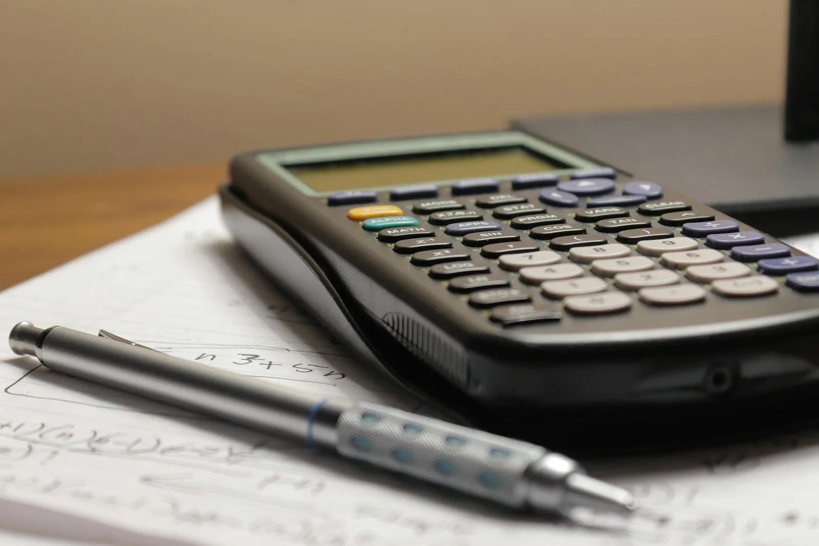 A calculator and pencil on a page of calculations. Illustrative photography, not a local listing.