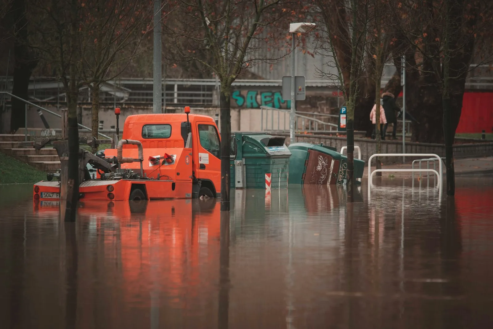 Floodwater surrounding a parked vehicle on an urban street. This is not a Texas property-risk assessment. Illustrative photography, not a local listing.