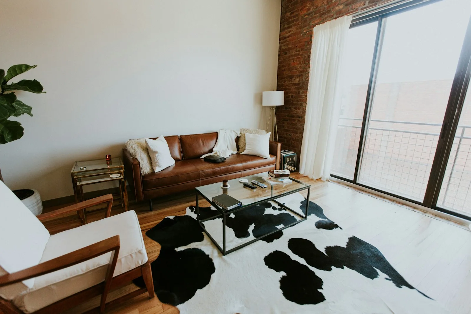 A furnished living room with a sofa, plants and a record player. Illustrative photography, not a local listing.