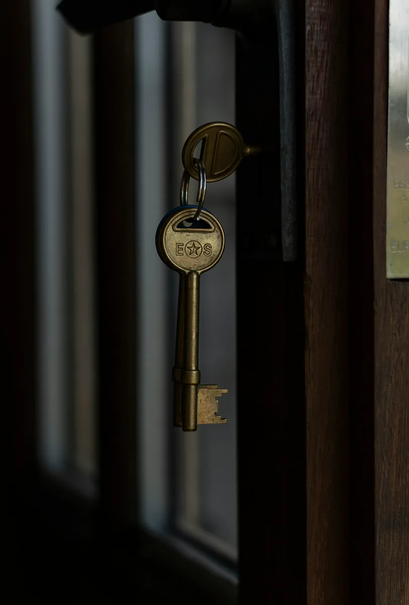 Keys hanging in the lock of a door. Illustrative photography, not a local listing.