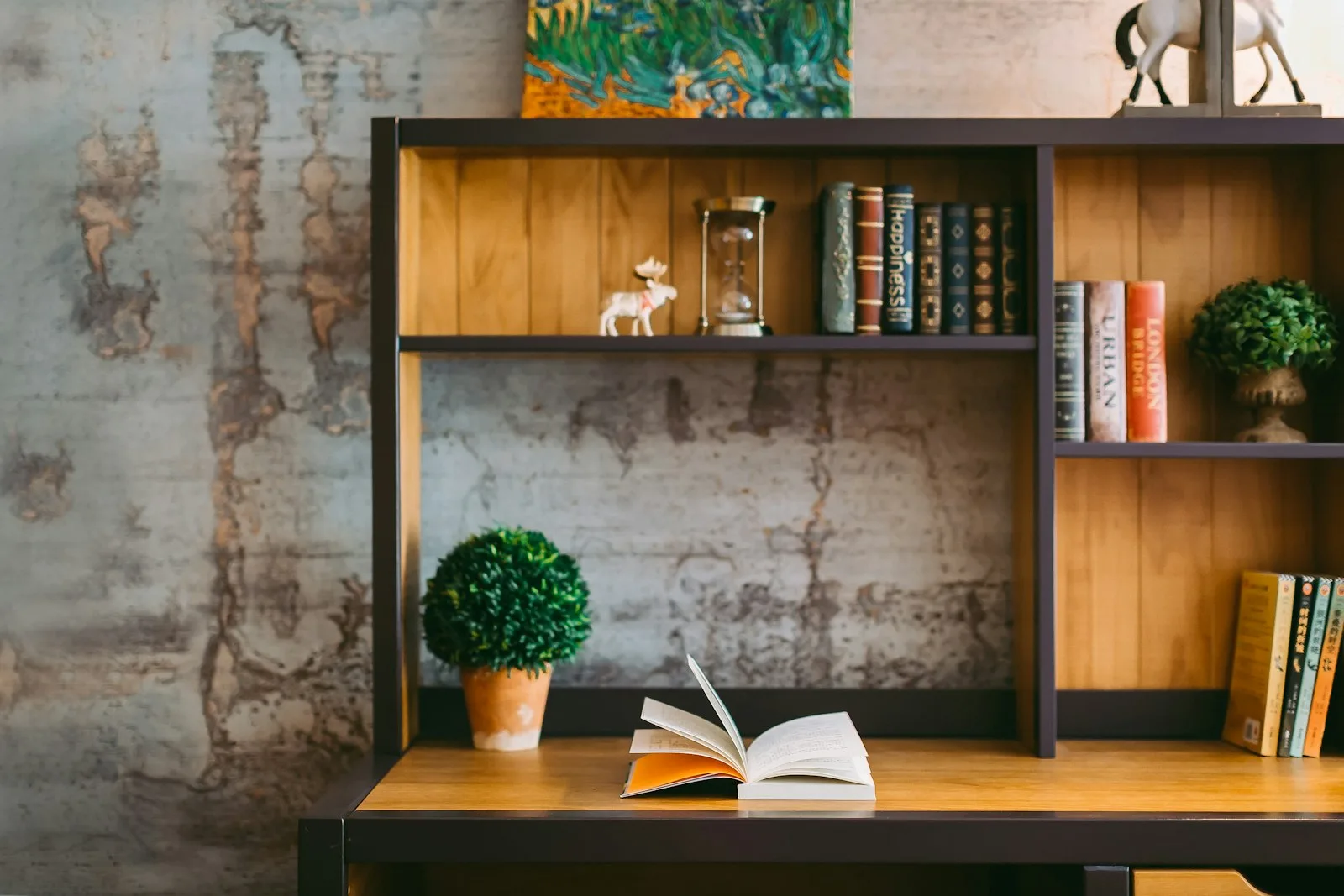 An open book on a desk beside bookshelves. Illustrative photography, not a local listing.