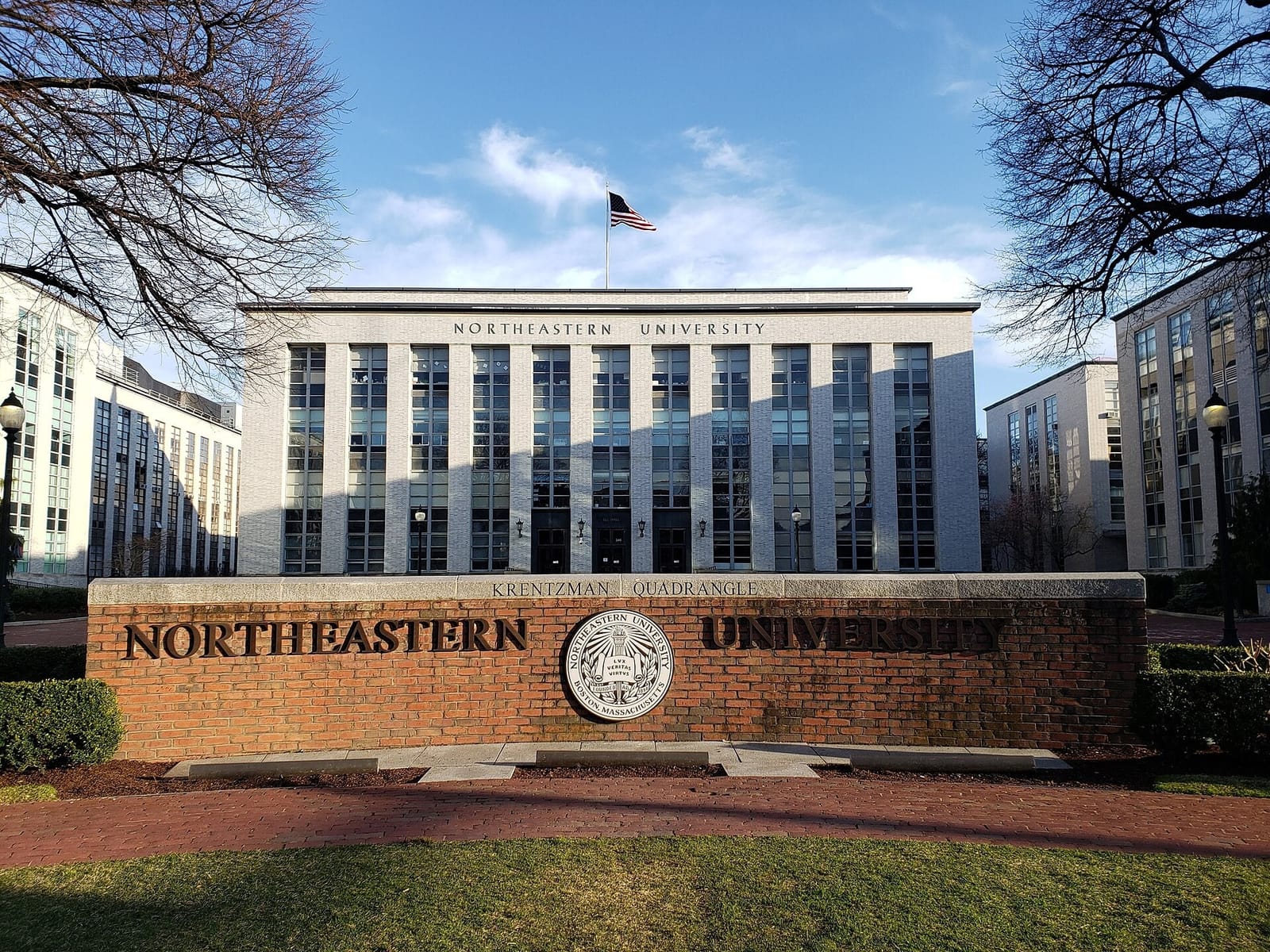 Northeastern University sign at Krentzman Quad with Ell Hall behind it in Boston.