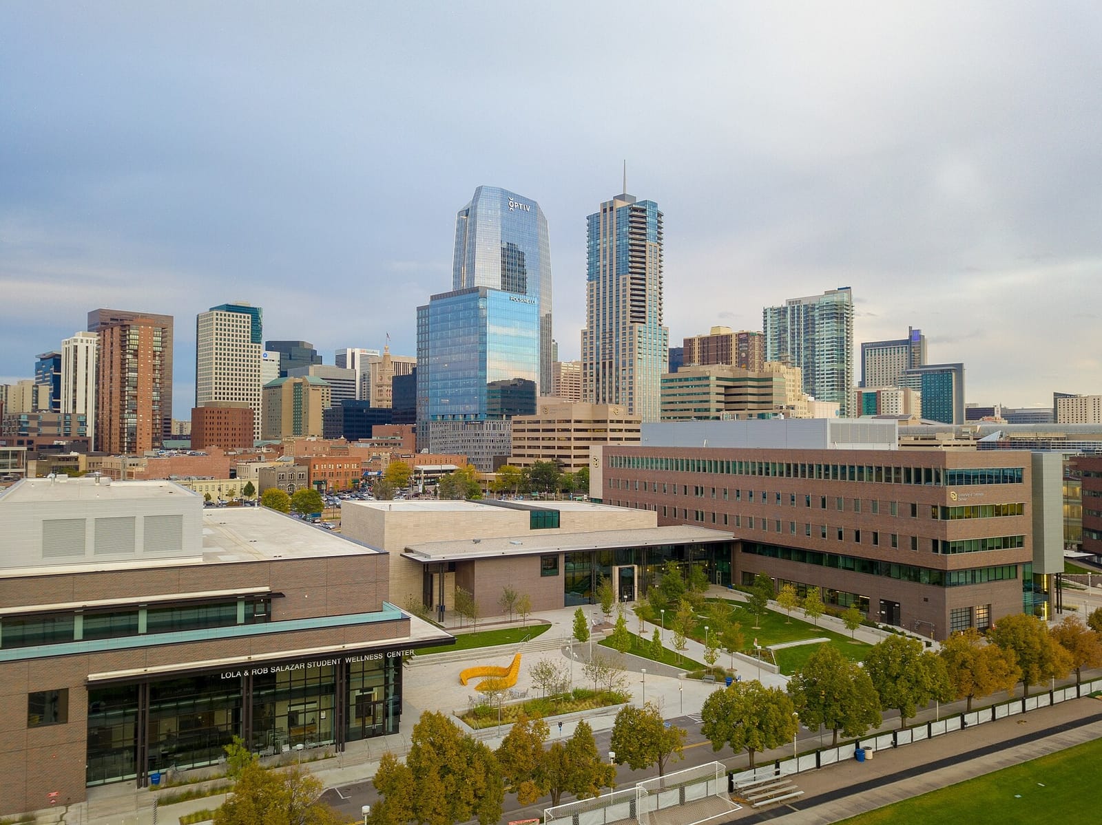 CU Denver Student Wellness Center and Student Commons Building with the downtown Denver skyline beyond.